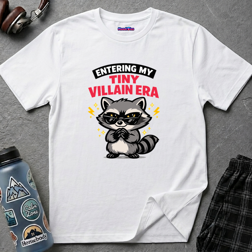 Cute raccoon wearing glasses rubbing hands mischievously with text ENTERING MY TINY VILLAIN ERA