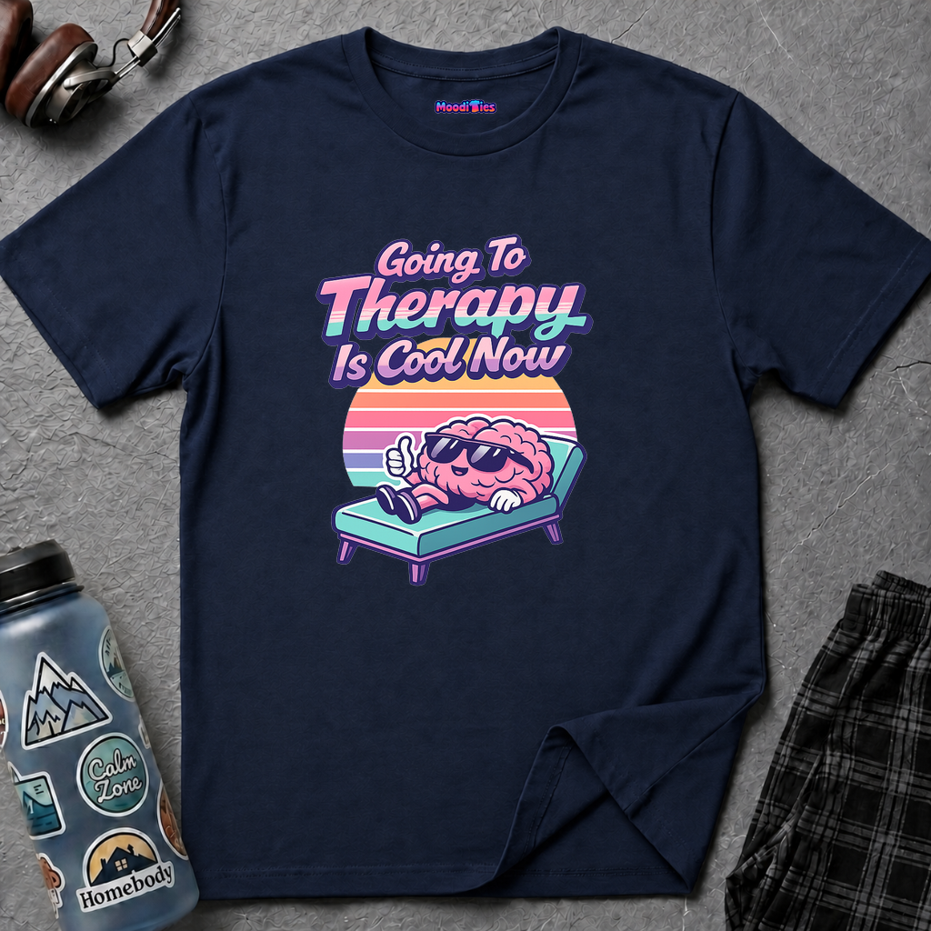 Text "Going to Therapy Is Cool Now," with brain wearing sunglasses relaxing on a lounge chair in front of a retro gradient sunset